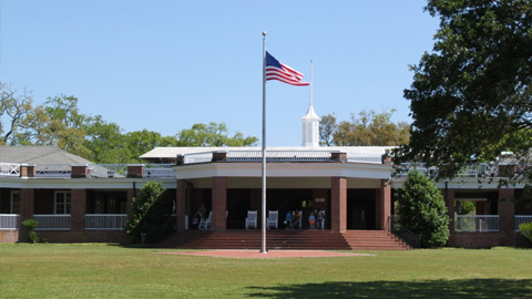 The St. Simons Island Casino Building. a flag in front of a red brick building