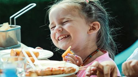 St. Simons Island: A Summer Vacation for Kids AND Adults. a little girl smiling while eating
