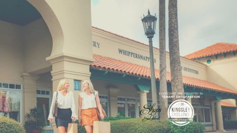 The Shops at Sea Island. two women with shopping bags in front of a spanish style building
